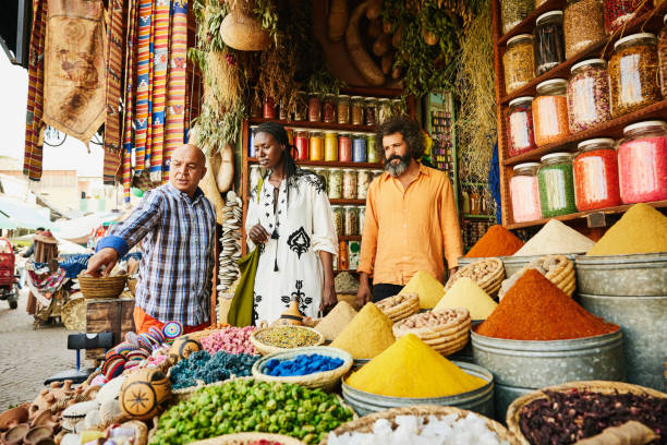 wide-shot-couple-talking-to-spice-shop-owner-in-the-souks-of-marrakech